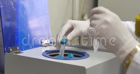 一位在实验室工作的科学家她在离心机里放了一些小瓶视频的预览图