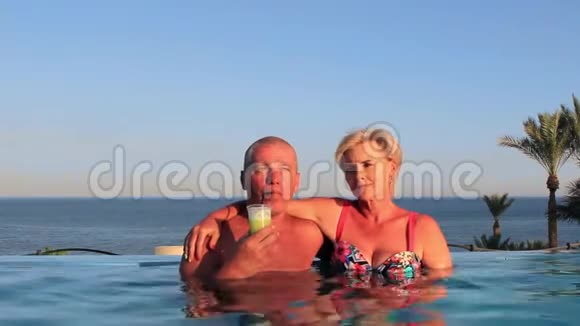 美丽的年轻夫妇在游泳池的度假胜地休息视频的预览图