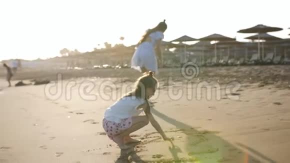 海边的两个姐姐在沙滩上画画视频的预览图