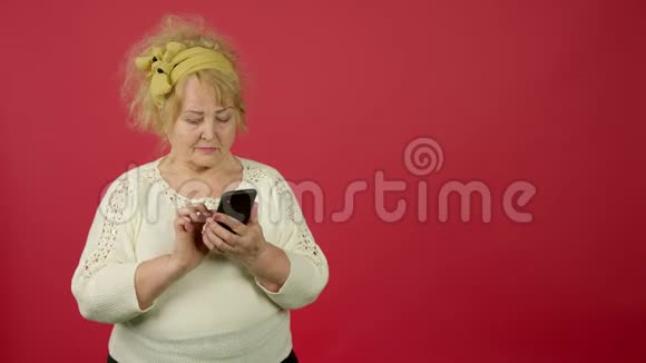 老年超重女性在使用智能手机时目光远离面带微笑视频的预览图