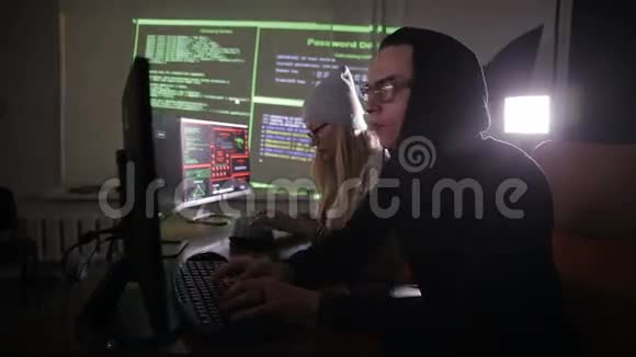 黑客团队黑客电脑在黑暗的房间里工作视频的预览图