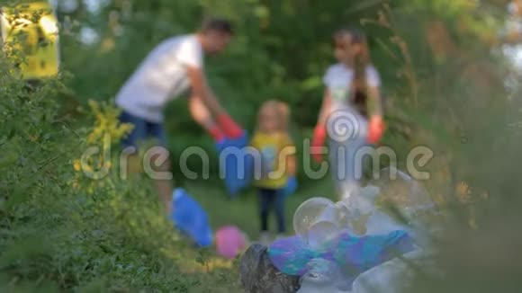生活垃圾问题母亲和父亲带着小女儿在没有重点的时候把垃圾收集到垃圾袋里视频的预览图