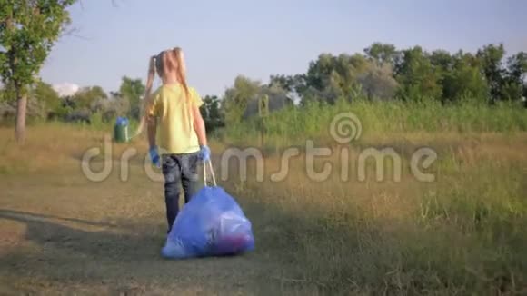 孩子们反对生态污染可爱的小女孩拉一个大垃圾袋与垃圾在道路上根据指针视频的预览图