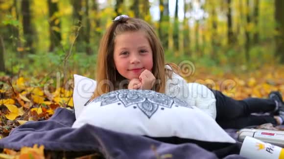 野餐的漂亮女孩躺在秋天的森林里视频的预览图