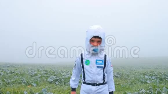 一个穿着宇航员服装的男孩回到了野外视频的预览图