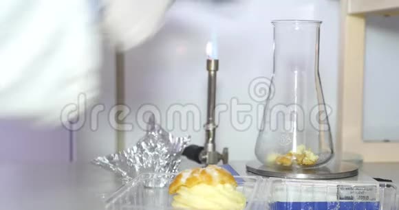 一位科学家在实验室里拿了一些食物的例子然后把它们放进一个Erlenmeyer烧瓶里进行进一步的测试视频的预览图