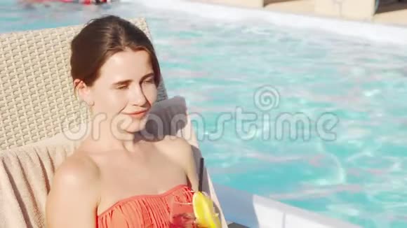 美丽的幸福女人在泳池边喝鸡尾酒视频的预览图