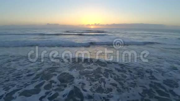 从卫星冲浪海滩佛罗里达大西洋海洋平静的白浪中观看日出的4k无人驾驶飞机视频的预览图