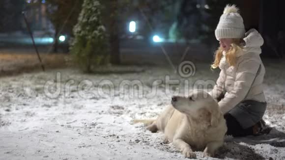家庭中宠物的幸福生活冬天漂亮的女孩在户外抚摸她的狗视频的预览图
