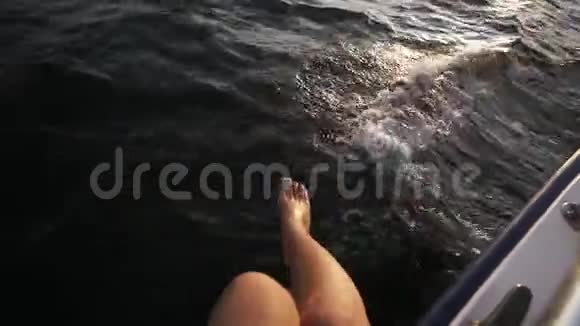 在海上散步期间一位漂亮的女士她的腿在游艇上嬉戏地悬挂在海面上阳光和深蓝色视频的预览图