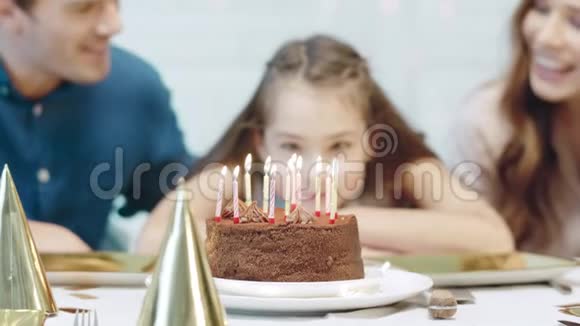 特写微笑的生日女孩在豪宅里吹12支生日蜡烛视频的预览图