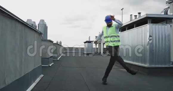 在建筑工地的屋顶上年轻漂亮的建筑师或工程师穿着安全的衣服兴奋地跳舞视频的预览图