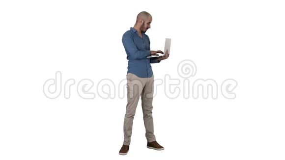 年轻的中东商人站在笔记本电脑上打字时他手里拿着白色背景视频的预览图