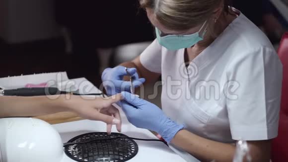 戴面具的指甲师傅在美甲工作室修指甲视频的预览图