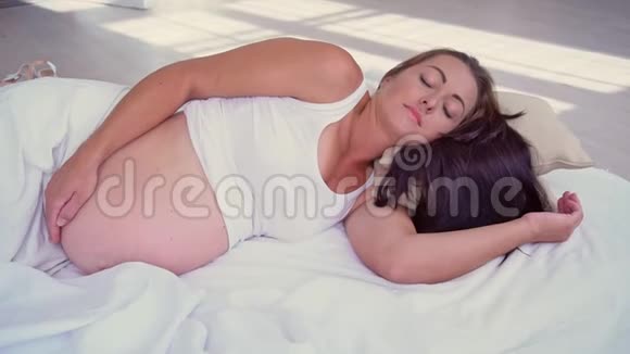 孕妇躺在床上抚摸着一个大肚子视频的预览图