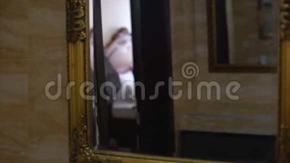 穿浴袍的女孩醒来后照镜子晨曦倒影视频的预览图