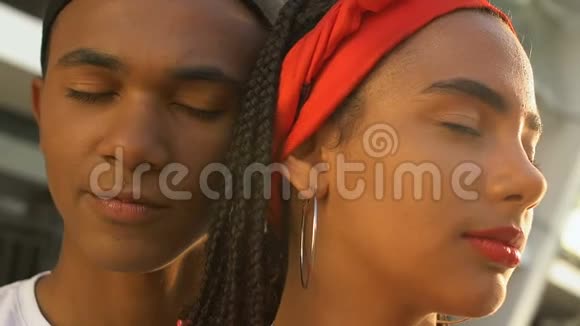 非裔美国青少年夫妇闭着眼睛拥抱梦想着未来视频的预览图
