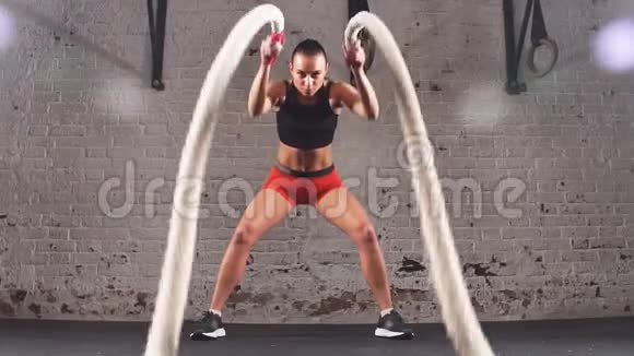 运动缓慢的年轻女子在健身房用战绳锻炼视频的预览图
