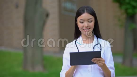 微笑女医生在医院公园工作医学研究视频的预览图