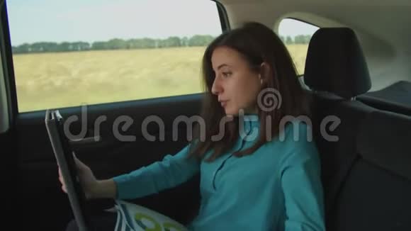 女企业家在汽车上做数字平板电脑视频的预览图