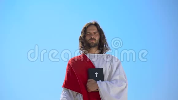 身穿长袍的传道者手握圣经祝福基督徒视频的预览图