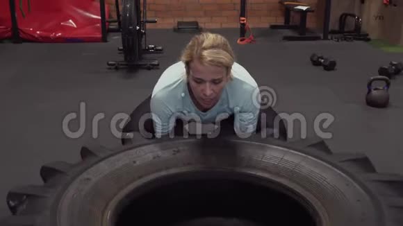 在健身房做轮胎翻转运动的女人视频的预览图