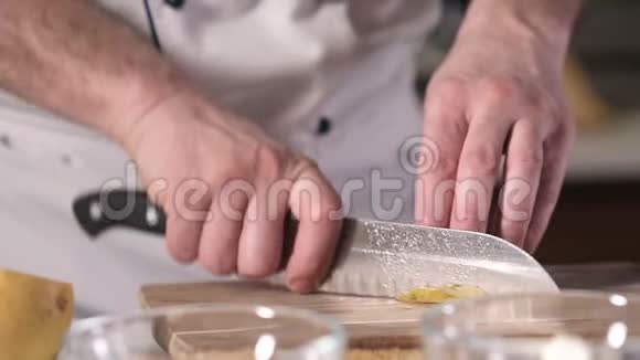 餐厅厨房的厨师用锋利的刀切出一个成熟的多汁梨视频的预览图