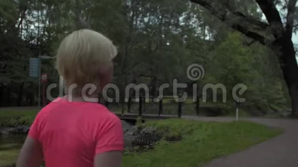 镜头稳定镜头围绕着在公园里奔跑的女人中弹视频的预览图