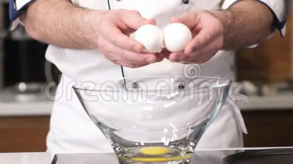 厨师把一个鸡蛋打碎成一个透明的玻璃盘子视频的预览图