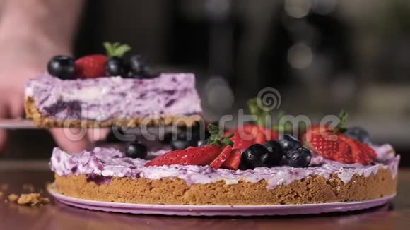 厨师用刀子切一块蛋糕上面有多汁的草莓和蓝莓视频的预览图