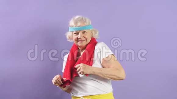 健康活跃的退休妇女穿着运动服看着镜头脸上带着光束视频的预览图