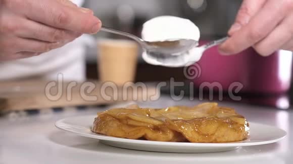 厨师把一份冰淇淋从勺子里放在美味的烤梨派上视频的预览图