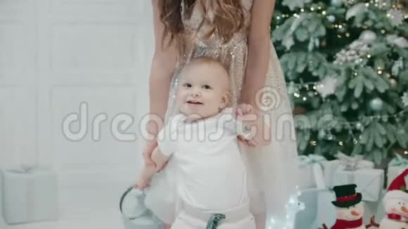 现代家庭中带着礼物盒跳舞的微笑男婴的肖像视频的预览图