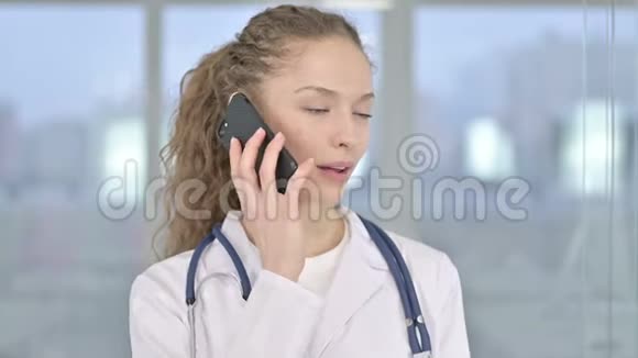开朗年轻女医生在智能手机上说话的画像视频的预览图