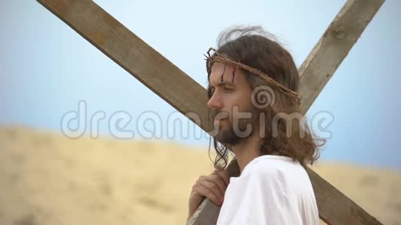耶稣基督带着荆棘的冠冕背着十字架为罪人向神祷告视频的预览图