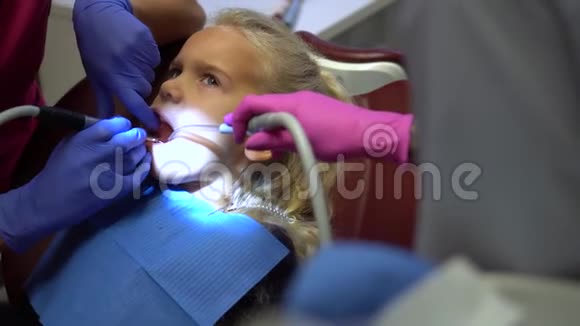 女孩在钻齿龋时张开嘴医生手工作视频的预览图