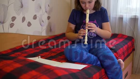 坐在床上玩长笛的女孩视频的预览图