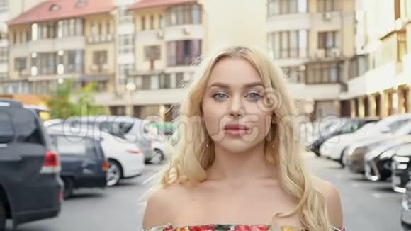 穿着夏装的金发美女在停车场摆姿势摄像机线路妇女步态视频的预览图
