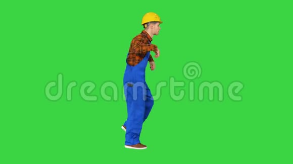 年轻的建筑工人戴着安全帽在绿色的屏幕上跳嘻哈舞铬钥匙视频的预览图