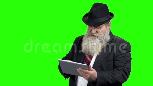 长胡子的老人使用平板电脑视频的预览图