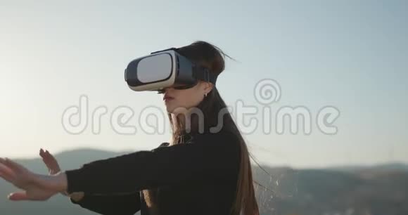 未来就是现在虚拟现实概念女性佩戴未来派VR盒耳机女人在户外使用虚拟现实眼镜女孩视频的预览图