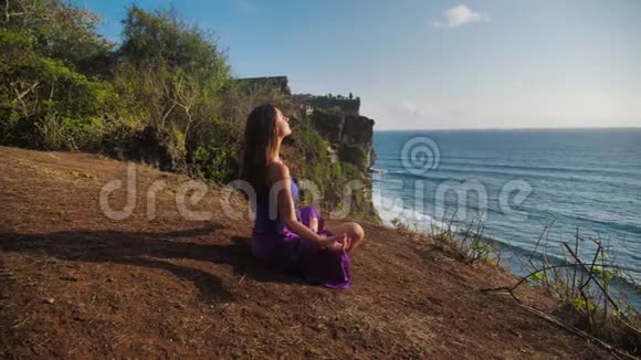 美丽健康的女性轻轻地呼吸坐在莲花或苏哈萨纳的姿势冥想或练习瑜伽和视频的预览图