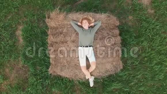 夏天女孩躺在干草堆上空中录像视频的预览图