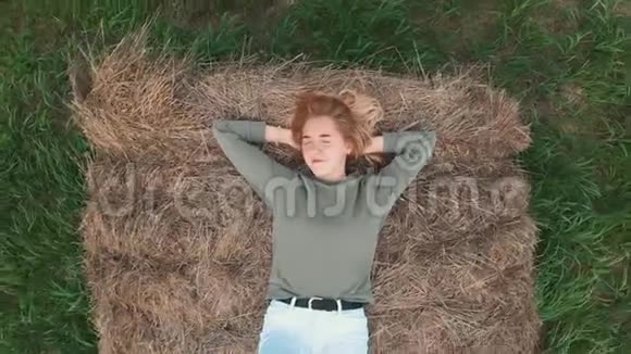 夏天女孩躺在干草堆上空中录像视频的预览图