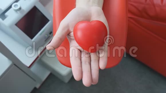 红胶心在一手人手在捐献静脉血抓住挤压应力球献血概念视频的预览图