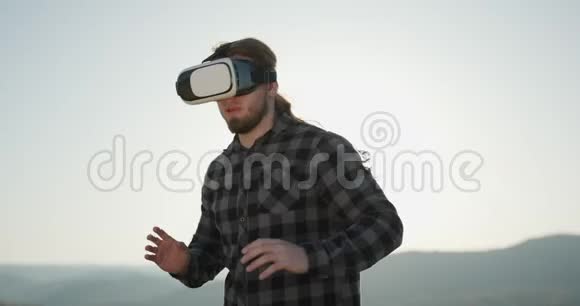 关闭年轻人戴虚拟现实眼镜护目镜现代使用VR耳机外面使用现代技术3视频的预览图