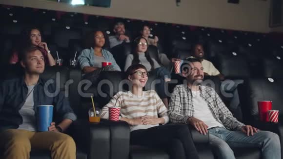 快乐的女孩和男人在电影院看电影笑着玩视频的预览图