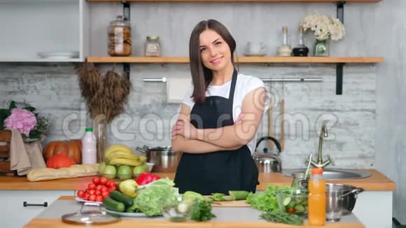 迷人的微笑年轻家庭主妇在舒适的厨房里做新鲜的开胃食品视频的预览图