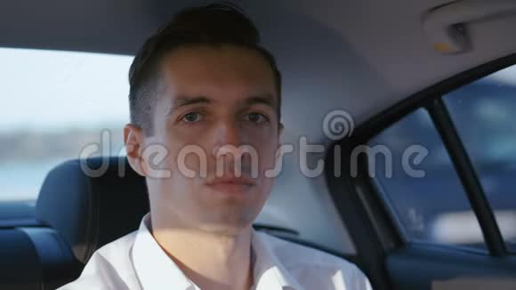 特写商人与司机乘汽车旅行的肖像穿白衬衫的年轻人乘出租车视频的预览图