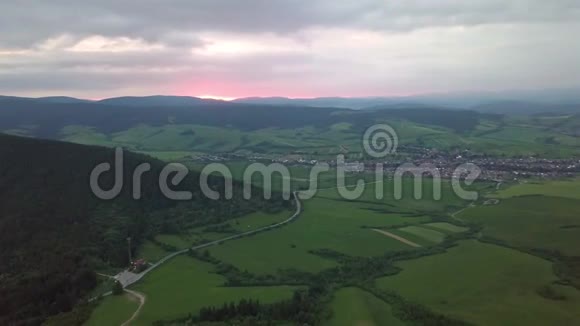 日落时以公路和村庄为背景的塔特拉斯山的鸟瞰图视频的预览图